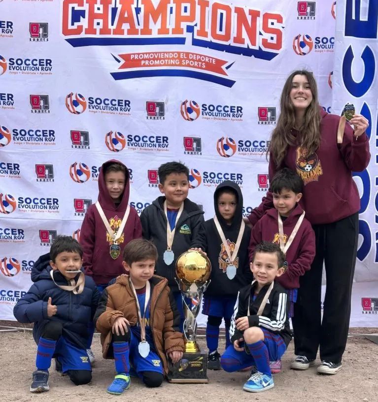 Los más pequeños del club con sus medallas y el trofeo de campeones
