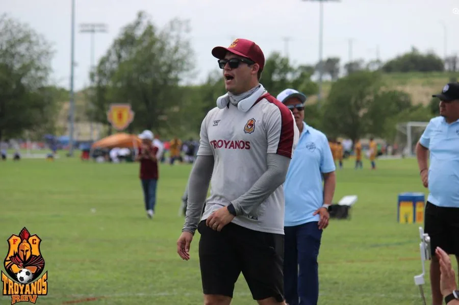 Entrenador de Troyanos dirigiendo desde la banda durante un partido